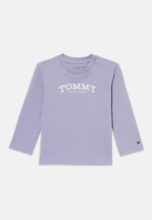 Fialkově fialové tričko pro miminko s dlouhým rukávem, s nápisem "TOMMY HILFIGER" na hrudi a malým logem na manžetě levého rukávu.