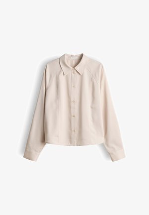 Camicia beige a maniche lunghe con bottoni, colletto e cuciture sagomate, mostrata distesa su sfondo bianco.