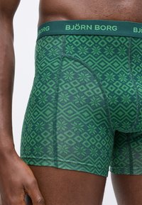 Boxer shorts verdi con un motivo geometrico. Realizzati in un materiale morbido con una vita a contrasto etichettata "BJÖRN BORG."