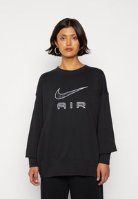 Black oversized sweatshirt made of cotton-blend fabric, featuring a white Nike logo and 'AIR' text centrally printed on the front.