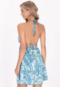 Blaues Halterkleid mit Paisley-Muster, Rückenschnürung, gerafftem Saum und leichtem Stoff. Es zeigt aufwendige Designs in verschiedenen Blautönen.