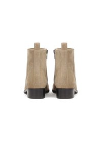 Botine din suede bej, cu un design elegant, fermoare laterale și un toc negru mic, prezentând cusături verticale pe laterale.