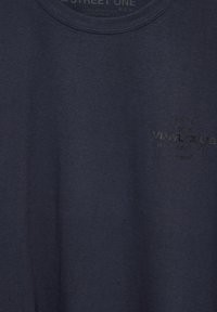 Námořnická bavlněná tričko s kulatým výstřihem, které na přední straně zdobí jemně potištěné logo s nápisem "Vinyl Club". Hladká textura.