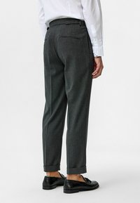Grijze gestreepte broek met een getailleerde pasvorm, voorzien van opgerolde boorden en een tailleband met verstelbare sluiting. Achterzakken zijn inbegrepen.