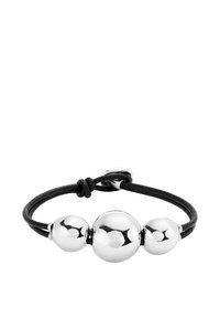 Pulsera de cuero negro con tres cuentas de metal plateado brillante de tamaños variados, aseguradas con un nudo y un cierre de metal.