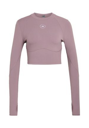 Długi top crop w kolorze mauve z okrągłym dekoltem, otworami na kciuki i małym białym okrągłym logo na środku klatki piersiowej.