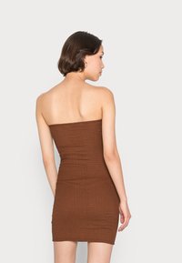 Vestido castanho sem alças feito de tecido texturizado, design ajustado e corte até ao joelho, exibindo um padrão canelado nas costas.