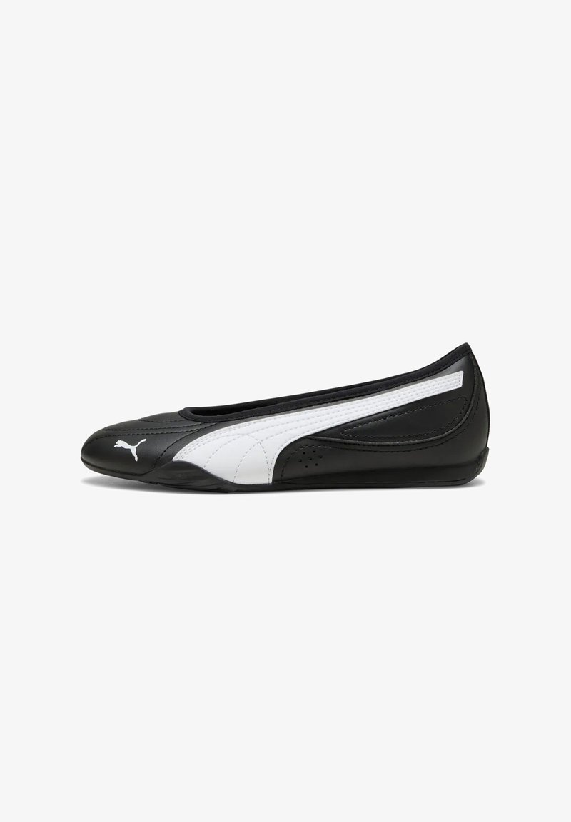 Chaussure ballerine plate Puma noire et blanche avec un bout arrondi et le logo Puma à l'avant, présentée de profil sur fond blanc.