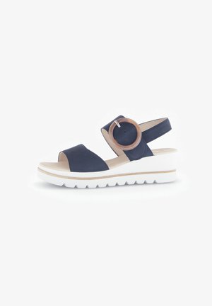 Marineblauwe wedge-sandalen met een ronde houten accent, verstelbare band en witte rubberen zool met een gestructureerd loopvlak.