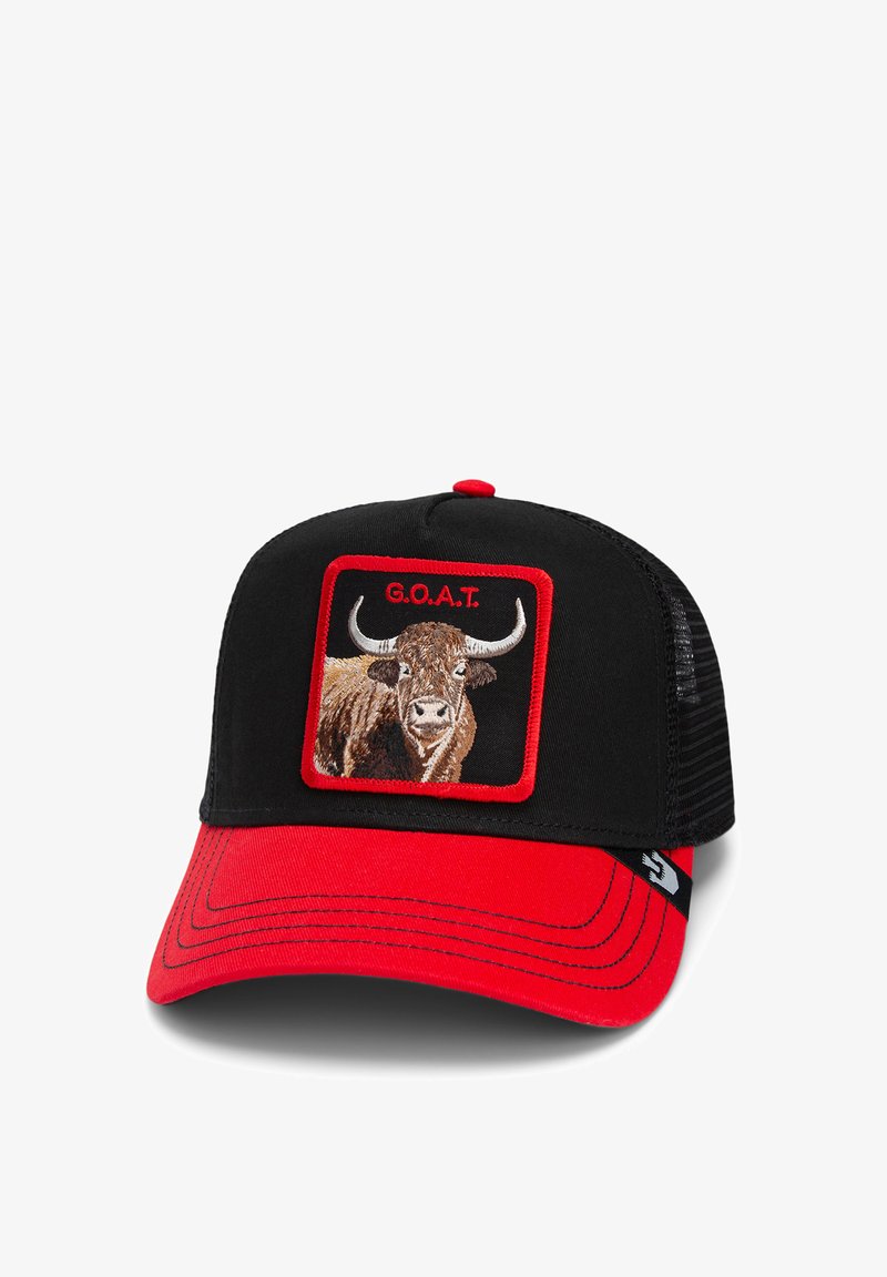 Gorra de camionero negra con visera roja; presenta un gráfico de una vaca bordado y el texto "G.O.A.T." en un recuadro rojo. Parte trasera de malla para ventilación.