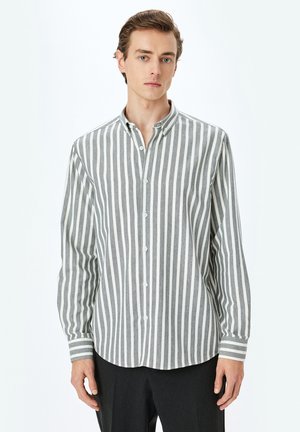 Camisa de algodón a rayas en gris y blanco, con botones en la parte delantera, cuello clásico, mangas largas, con rayas verticales y puños con banda.