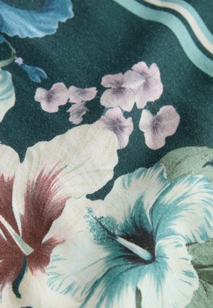 Zöld virágmintás szövet, amely hibiszkusz és árvácska mintákat tartalmaz pasztell árnyalatú kék, rózsaszín és fehér színekben, lágy, texturált megjelenéssel.