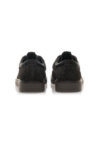 Scarpe in suede nere con un accentuato in pelle liscia sul tallone, forma arrotondata e suola texturizzata. La vista posteriore mostra un semplice design con lacci.