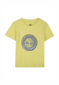 Gele katoenen T-shirt met korte mouwen, met een cirkelvormig, blauw en grijs Timberland-logo en twee drukknoopjes op de linkerschouder.