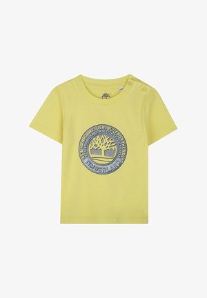 T-shirt di cotone giallo a maniche corte, con logo circolare Timberland blu e grigio e due bottoni a pressione sulla spalla sinistra.