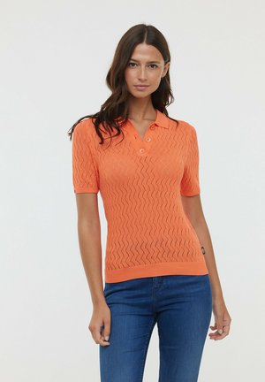 Polo à manches courtes orange avec un motif en zigzag texturé, trois boutons au col et des poignets et ourlet côtelés.