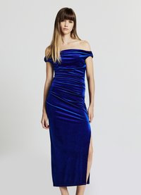 Schulterfreies, figurbetontes Kleid aus tiefblauem Samt mit seitlichem Schlitz und Raffdetails, das eine glatte Textur und eine elegante Silhouette präsentiert.