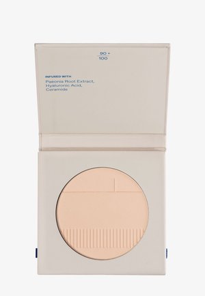 Compact beige cosmetic powder in a square pale beige case, labeled with ingredients Paeonia Root Extract, Hyaluronic Acid, and Ceramide.