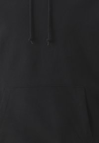 Haut à capuche noir avec cordons de serrage, poche kangourou à l'avant, texture douce et finition lisse. Pas de logos ou motifs visibles.