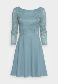 Robe bleu clair avec un corsage en dentelle et des manches trois-quarts, dotée d'une jupe évasée et d'une texture de tissu lisse.