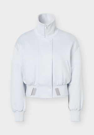 Veste courte blanche avec col montant, fermeture éclair sur le devant et boutons-pression, manches longues avec poignets côtelés et sangles ajustables à la taille.
