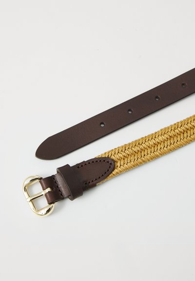 Ceinture en corde dorée tressée avec des accents en cuir marron foncé et une boucle en métal doré. Elle dispose d'une lanière en cuir lisse avec des trous d'ajustement.