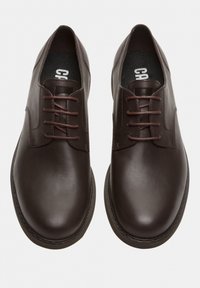 Scarpe in pelle marrone con una finitura liscia. Design a punta arrotondata, allacciatura centrale con fili marroni e una soletta testurizzata.