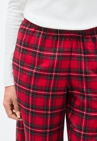 Κόκκινο καρό παντελόνι lounge με ελαστική μέση, διακοσμημένο με μαύρες και λευκές γραμμές σε καρό μοτίβο, κατασκευασμένο από απαλό βαμβακερό υλικό.