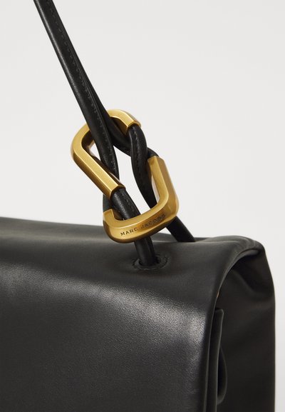 Schwarze Ledertasche mit glatter Textur. Sie verfügt über einen goldenen geometrischen Verschluss und Lederträger, was ein modernes Design schafft.