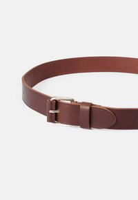 Brauner Ledergürtel mit glatter Textur, silberner Metallspange und fünf verstellbaren Löchern zur Anpassung der Größe. Flach liegend, zylindrische Form.