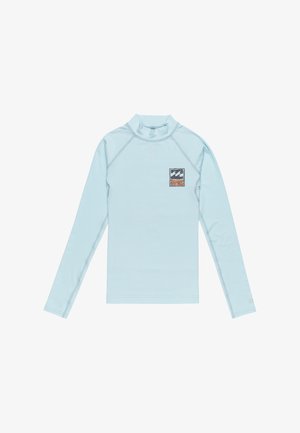 Rash guard de manga larga azul claro con un cuello alto. Presenta un pequeño logotipo en parche en el lado izquierdo del pecho y detalles de costura plana.