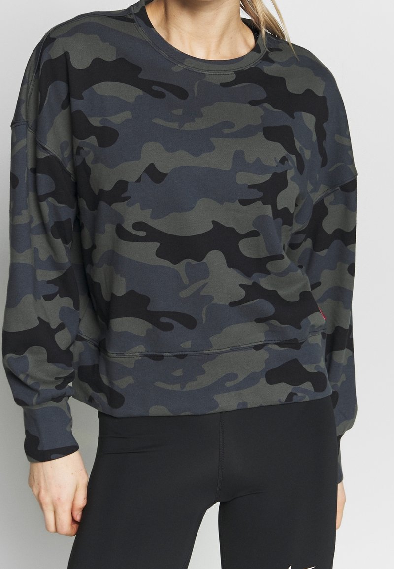 Sweatshirt camouflage dans des tons de vert et de noir, avec un col ras du cou, des manches longues et une coupe décontractée avec des poignets et un ourlet côtelés.