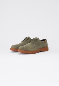Pantofi din suede verde măsliniu, cu șnururi, cu vârful rotund, dotati cu o talpă din cauciuc și detalii cusute, accentuați de un mic logo maro.