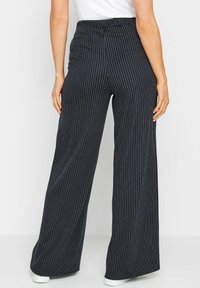 Zwart-wit gestreepte wijde pantalon met een elastische tailleband, met een zachte stofstructuur en een losse, vloeiende uitstraling.