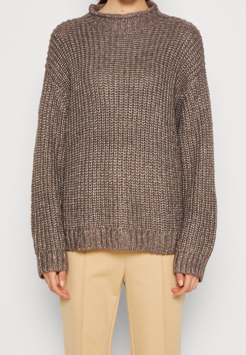 Maglione marrone lavorato a maglia con un collo alto, vestibilità ampia e polsini e orlo a costine. La texture è spessa, creando un aspetto caldo e accogliente.