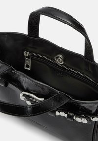 Czarna torebka z fakturowanej skóry z krótkimi uchwytami, srebrnymi detalami, kieszenią na zamek błyskawiczny i zapięciem na zatrzask. Wnętrze jest podszyte.