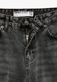 Jeans de mezclilla gris con cremallera y cierre de botón. Incluye un acabado desgastado y detalles de costura, etiquetados como W27 L32.