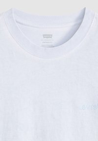 Svetlomodré vintage tričko s voľným strihom vyrobené z jemnej bavlny. Má okrúhly výstrih a decentne vyšívané logo Levi's na hrudi.