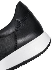 Black leather sneaker's heel with stitched panel details, white midsole, and black outsole featuring a ridged tread pattern.