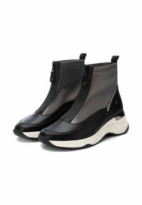 Botas de tobillo negras y grises con cremallera frontal, acentos de cuero texturizado, lengüetas de tirón y suelas gruesas de goma blanca.