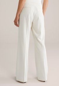 Biele nohavice s širokými nohavicami a hladkou textúrou, s dvoma zadnými vreckami a strihané na mieru v páse.