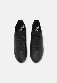 Zapatillas deportivas negras con un diseño texturizado y estriado. Cuentan con cordones, puntera redondeada y un cuello acolchado. Suela no visible.