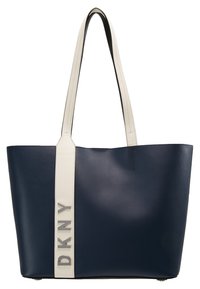 Marinblå läderhandväska med kontrasterande vit rem, med silverfärgad "DKNY"-logotyp. Slät textur och rymlig design.