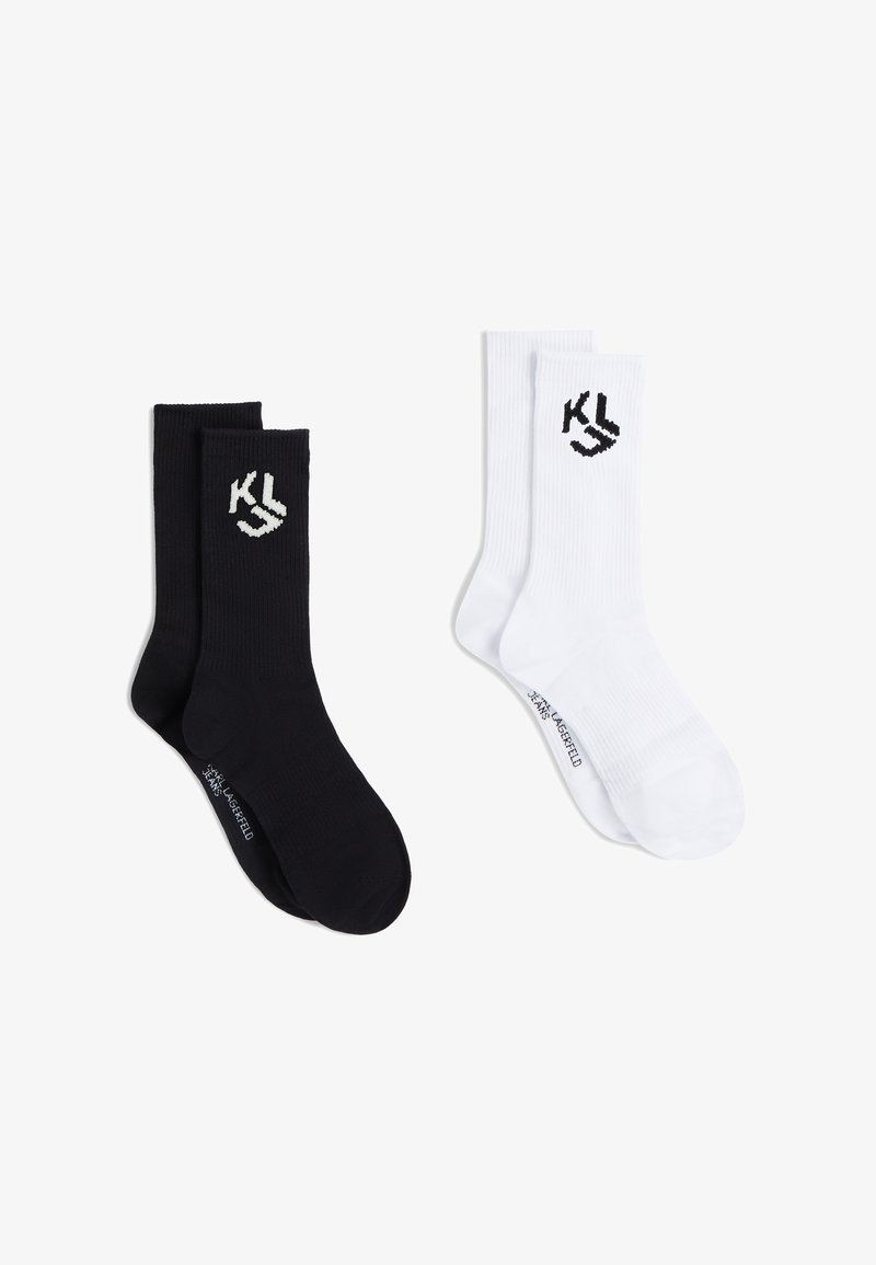 Deux paires de chaussettes côtelées mi-hautes, une noire et une blanche, chacune avec un logo "KL" près du haut et un petit texte près des orteils.