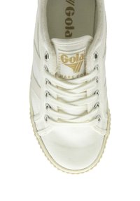 Vit canvas sneakers med guldlogotyp, platta snören, rund tå, texturerad sula och tre ränder längs sidorna. Klassisk design.