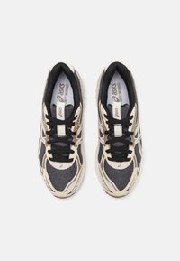 Black and gray athletic shoes featuring a textured fabric upper, white accents, and black laces. Lightweight design with cushioned interior.