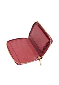 Portafoglio con cerniera in pelle color bordeaux con dettagli dorati. Presenta fessure per carte e una tasca trasparente per documento d'identità. Texture liscia, design compatto e quadrato.