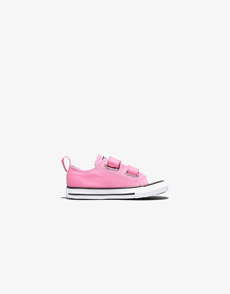 Pinkfarbener Canvas-Kinderschuh mit doppelten Klettverschlüssen, weißer Gummispitze und weißer Sohle mit schwarzen Streifen, seitliche Ansicht auf weißem Hintergrund.