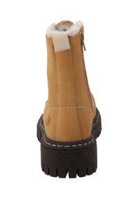 Tan læder ankelstøvle med faux fur foring, en struktureret brun gummisål og en bagtil lynlås for nem påklædning. Pyntet med syningsdetaljer.