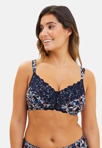 Lingerie floral navy avec des détails en dentelle, des bords festonnés et un accent central en forme de nœud. Tissu doux avec un motif aux couleurs mélangées, présentant des nuances de rose et de bleu.